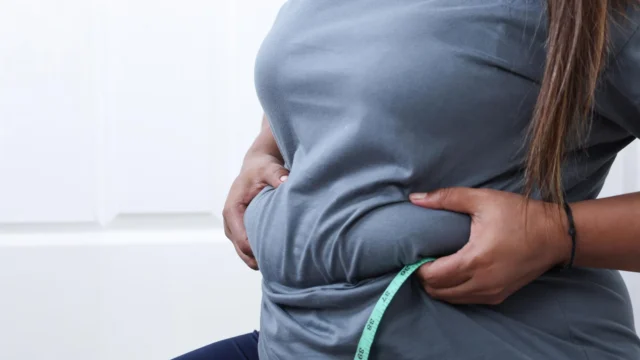 heavy-woman-pinching-belly-fat.webp.webp