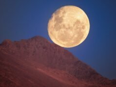 在這張 2025 年 11 月 6 日的照片中,月亮似乎從山脊上滾下來。