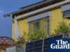 插入式阳台太阳能电池板将首次在英国上市 A man holds a solar panel on a balcony as another man looks on