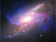 带有异常额外臂的发光星系| 2026 年 8 月 27 日当天的太空照片 a colorful swirl of light on a black background