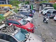 台风“海豚”袭击中国 超38万人撤离 Residents walk past vehicles damaged by a fallen wall in the aftermath of Typhoon Dolphin in eastern China’s Zhejiang province. PIC/PTI