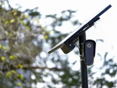 我辨别新设备是否是 Flock 相机的保证步骤 – CNET A camera and solar panel on the top of a post by a tree.