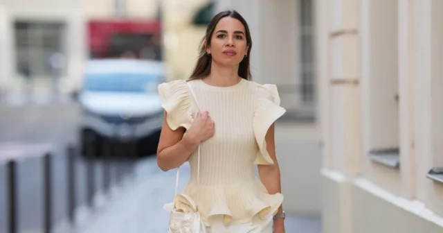 Behold, 13 of the Most Flattering Tops for Women Over 45 Who Want to Hide the Midsection PARIS, FRANCE - MARCH 10: Bambi Northwood-Blyth wears black leather pants, white jacket with buttons and brown Loewe bag outside the LOEWE presentation during the Womenswear Fall/Winter 2025/2026 as part of Paris Fashion Week on March 10, 2025 in Paris, France. (Photo by Raimonda Kulikauskiene/Getty Images)