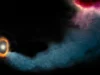 一条长达 1 万亿英里的宇宙气体“河流”将猎户座中的行星送入倾斜轨道 a tendril of blue-grey gas curves its way across a starry background toward a ring of bright orange gas around two brighter, smaller rings inside of it