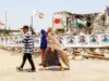 伊朗称在美国结束海上封锁之前不会重新开放霍尔木兹海峡 People walk past the destroyed Shajareh Tayyebeh primary school in Minab in Iran’s Hormozgan province, on Monday