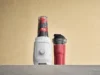 Vitamix 首款个人搅拌机 Nano 来了 – CNET The black Vitamix Nano next to its cup filled with an orange smoothie and plate of citrus.