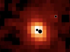 科学家在遥远星系内发现3个濒临碰撞的超大质量黑洞 A pixelated reddish image. There are three black circles showing where the three black holes are located.