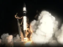 火箭实验室将日本私人地球观测卫星发射到轨道(视频) A dark rocket ignites its engines, lifting off a launch pad in a dark night setting.