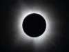 在太空的这一天! 1914 年 8 月 21 日:日全食探险队因第一次世界大战坠毁 A black circle against a black background surrounded by white wispy tendrils