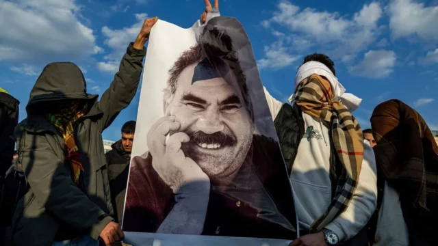 Turkey's parliament approves a pardon-like bill for thousands of PKK militants FILE - Youngsters hold a photograph of Abdullah Ocalan, the jailed leader of the militant Kurdish group, or PKK, in Diyarbakir, Turkey, Feb. 27, 2025.