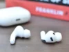 苹果似乎已经泄露了配备摄像头的 AirPods Apple's current-generation AirPods Pro are shown next to a book