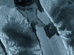 卫星观测到格陵兰岛十多年来最严重的浮冰损失2026 年 8 月 24 日当天的太空照片 A variety of shades of dark blue, gray and white in large panels of ice and water.